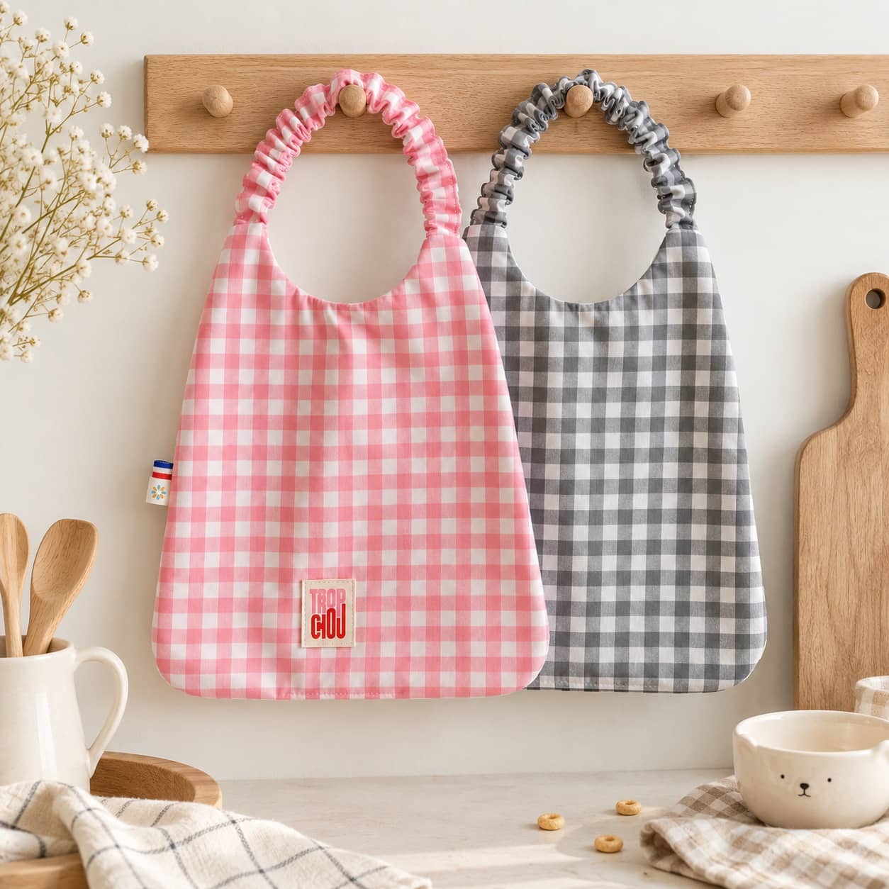 Duo de bavoirs serviettes 2 Pink and gray Vichy-print Timouny children's bibs hanging in a kitchen
