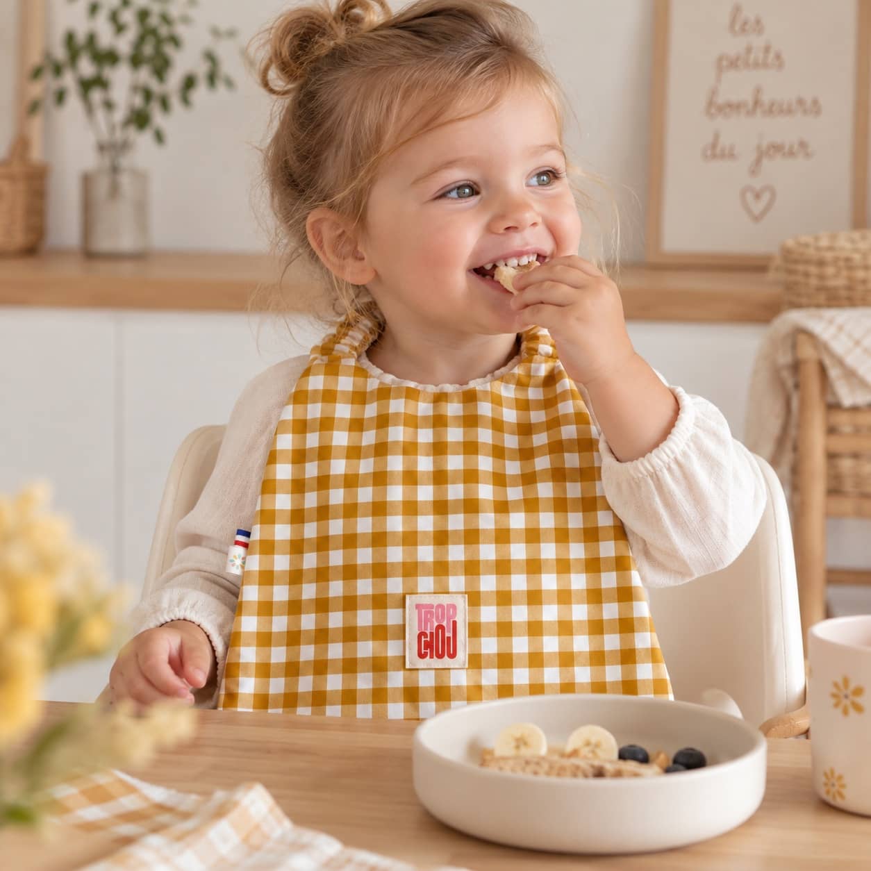 Bavoir serviette Curry 2 Petite fille portant un bavoir élastiqué Vichy Curry Timouny pendant le repas