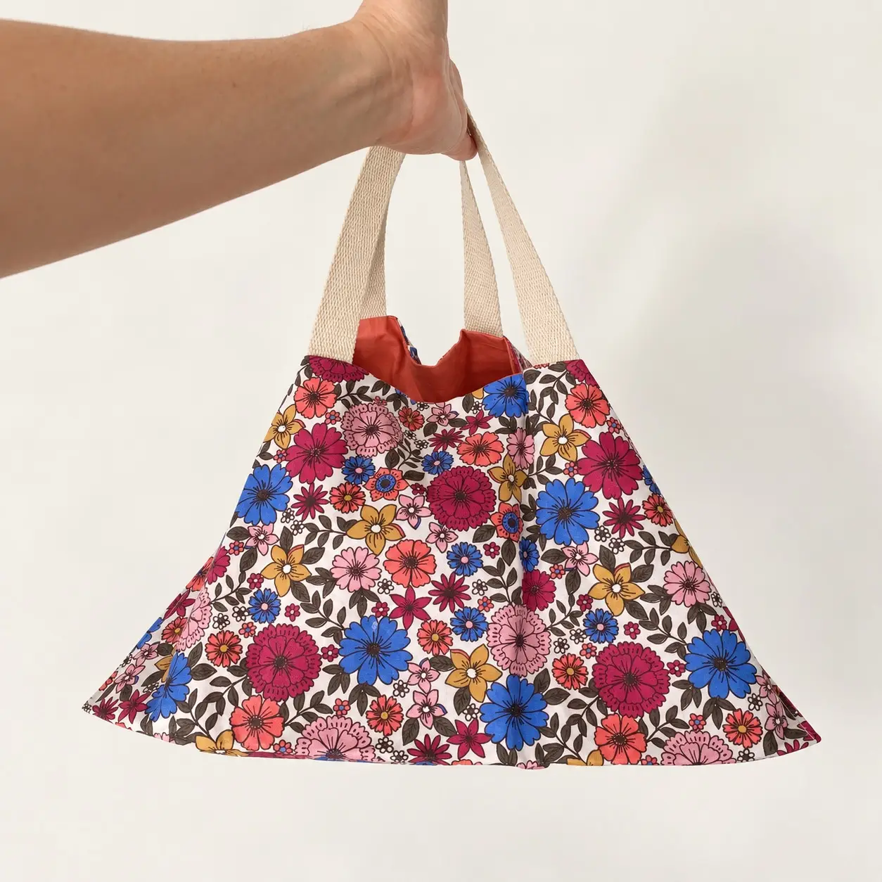 Sac à tarte fleuri Joséphine – Imperméable et réversible, fabrication française 2 Sac à tarte fleuri Timouny suspendu par ses deux anses écrues, montrant sa forme lors du transport.